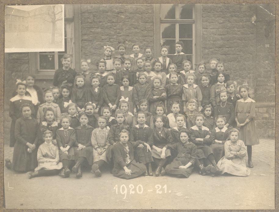 Historisches Gruppenfoto einer Schulklasse 1920/21 mit zahlreichen Kindern und einem Lehrer